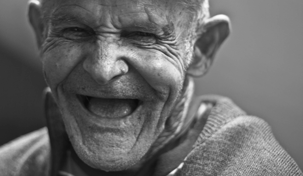 a close up of a elderly man laughing